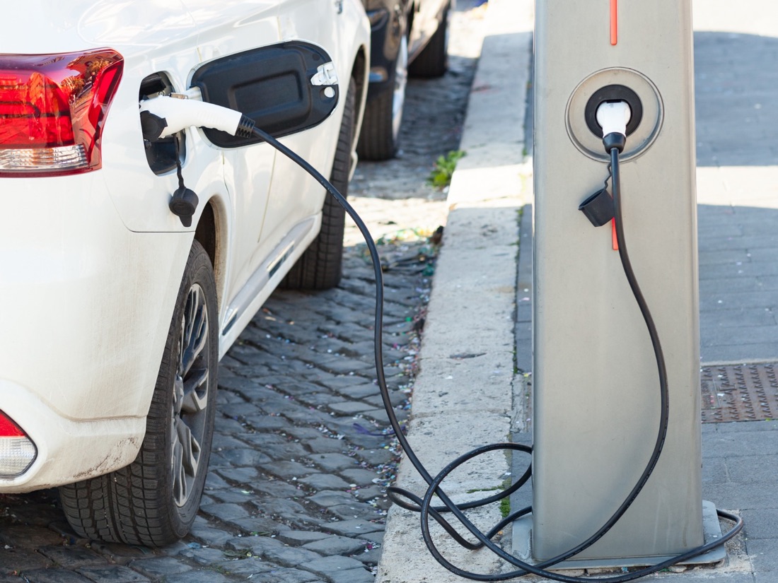 Auto eléctrico conectado a un cargador de poste